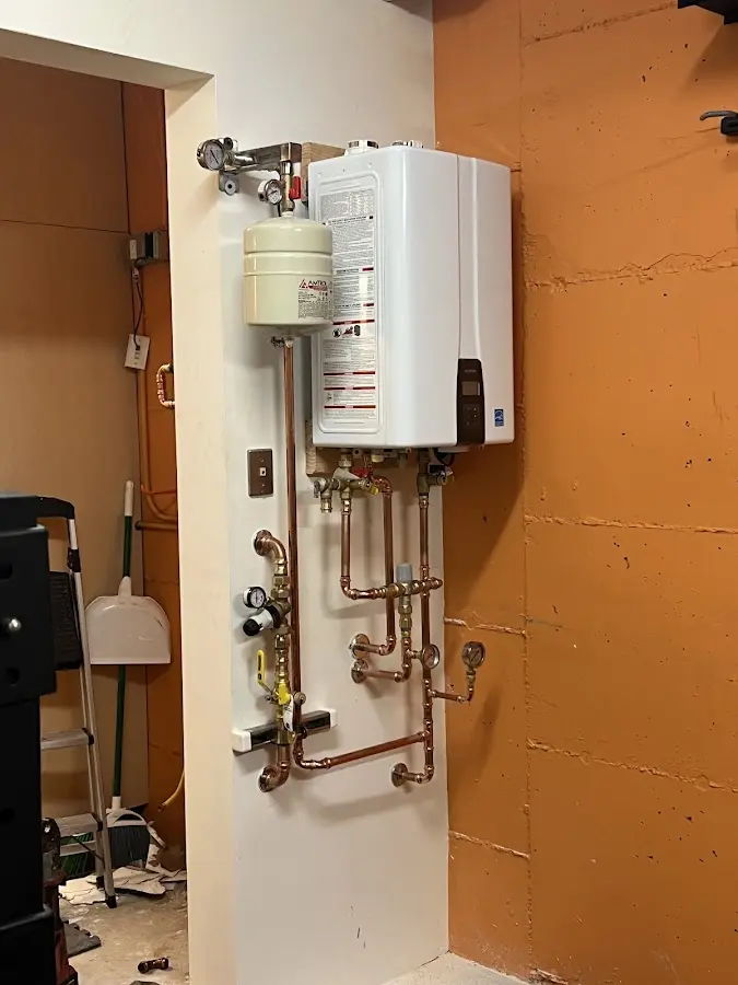 Plumbing technician inspecting water heater connections in Hendersonville